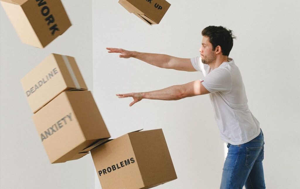 man pushing boxes labeled with anxiety away