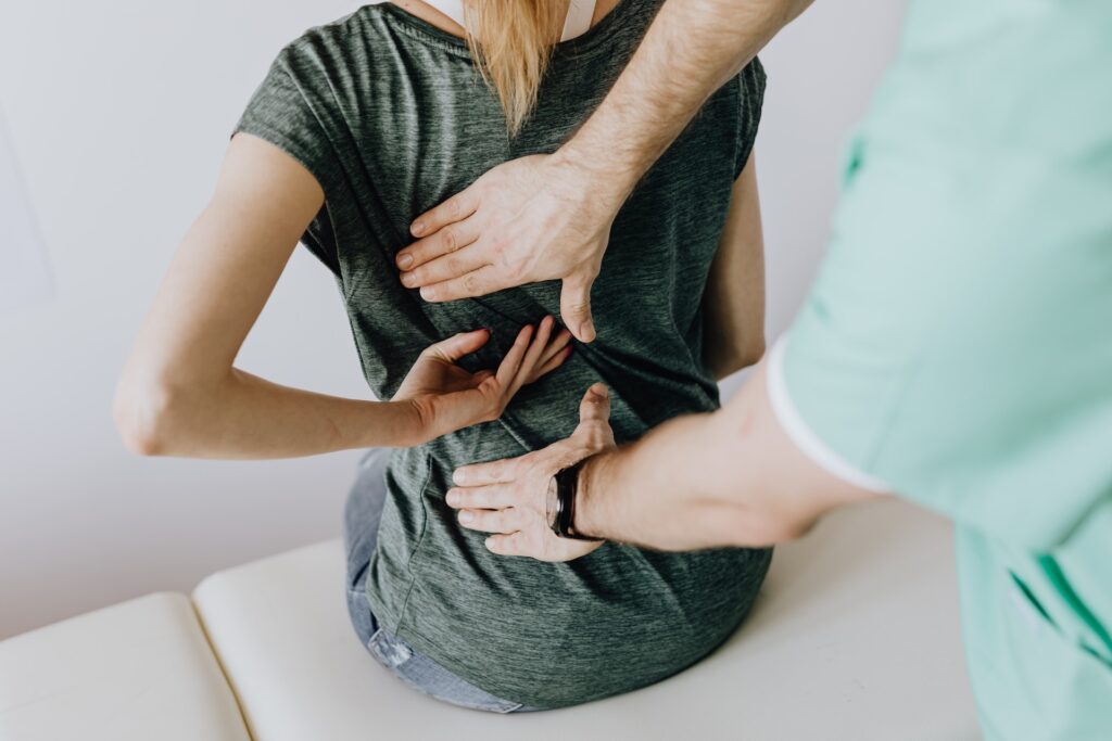 woman with back pain being checked by a physician