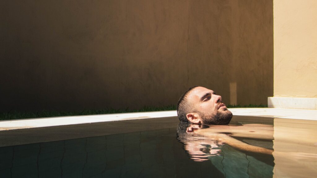 man relaxing in the water with really calm water