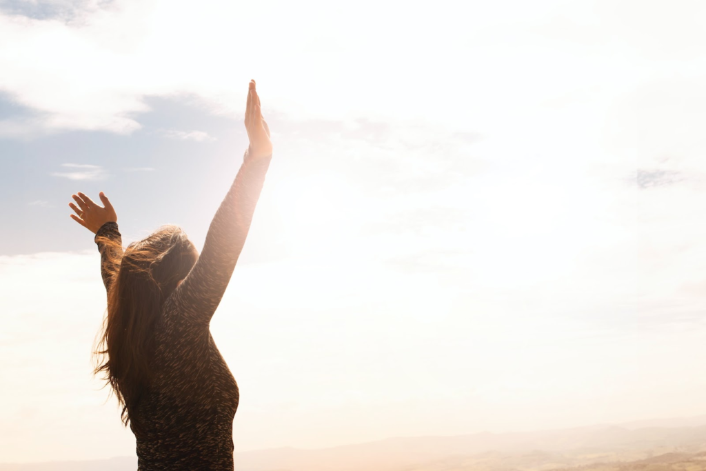 woman with her hands in the air enjoying the day