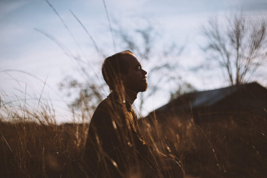 man meditating sitting outdoors