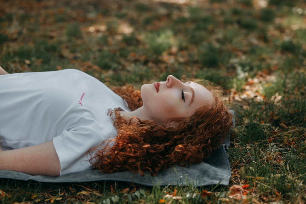 woman meditating laying down out in nature