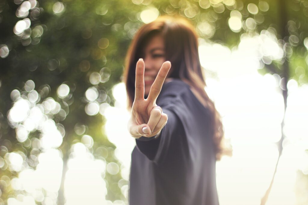 woman doing a victory sign, smiling happy without pain