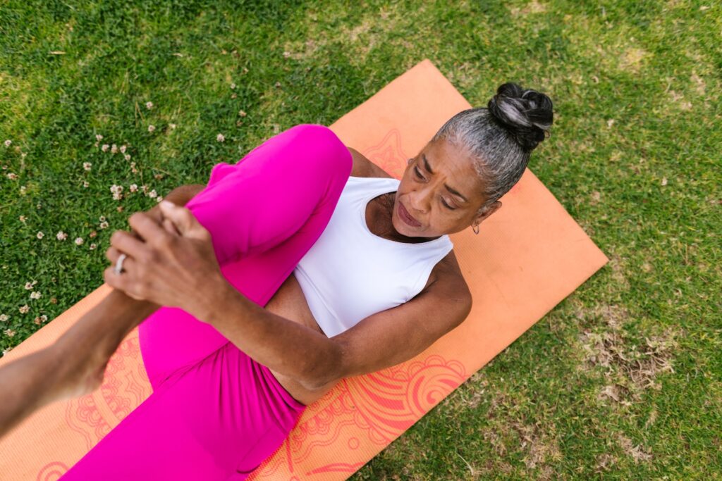 woman stretching her legs on a  yoga mat