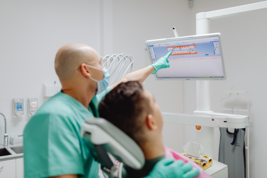 dentist showing a man his dental needs on the screen