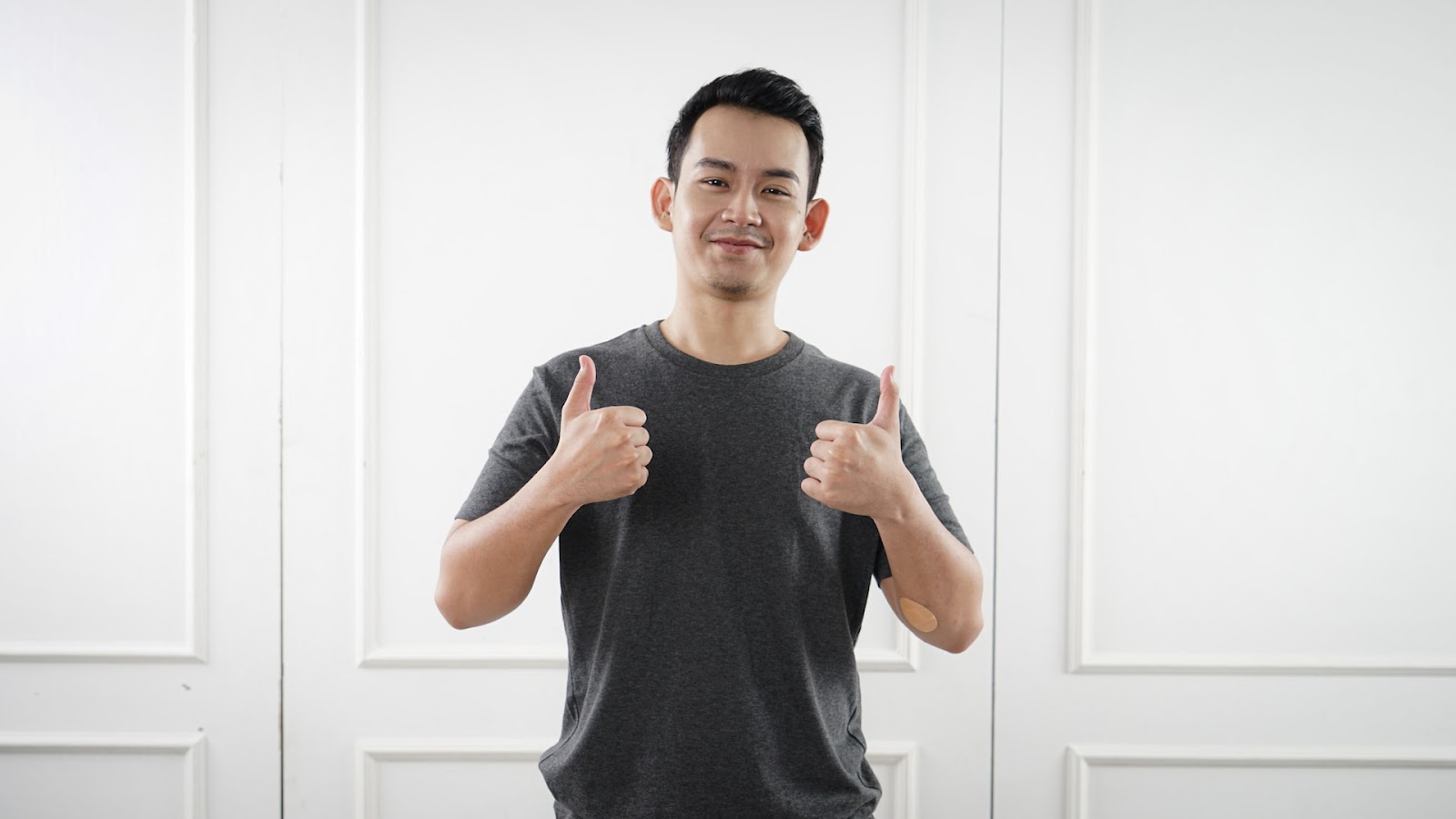 man smiling and showing two thumbs up