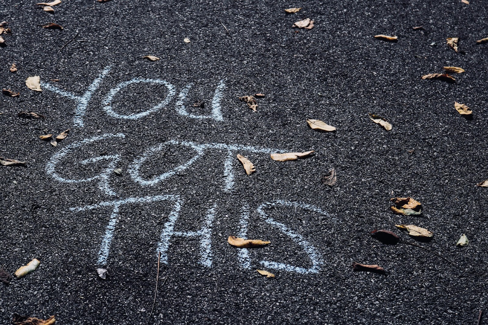 A message that reads "you got this" written with chalk on the pavement