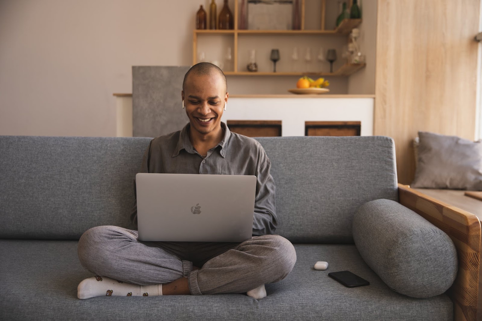 person sitting on the couch and smiling while receiving online hypnotherapy for trauma and ptsd