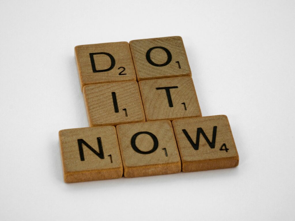a phrase "do it now" made with scrabble pieces