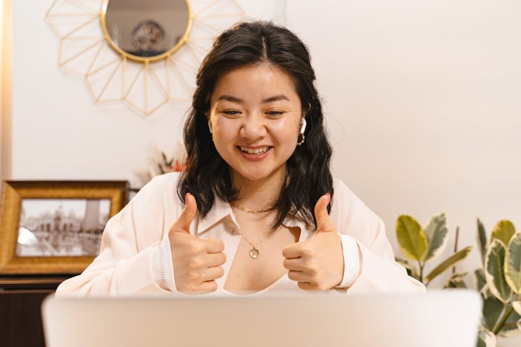 woman smiling and showing two thumbs up in sign of approval